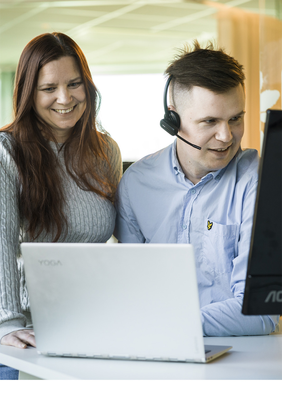 Utbildning på Real fastighetssystem. Två personer framför dator. Man, kvinna headset.